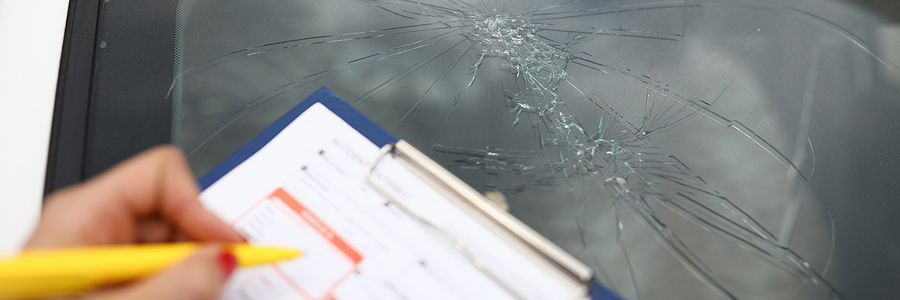 An agent draws up documents for broken windshield in car.